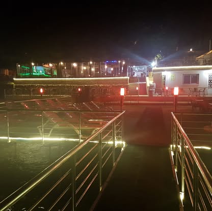 Gece ışıklarıyla aydınlatılmış iskele terası ve korkuluklar